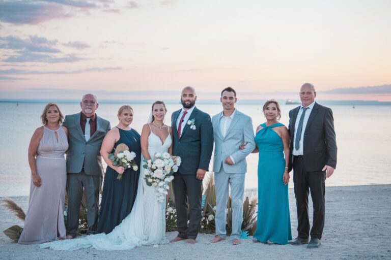 a group of people standing next to each other on a beach, wedding in the Dominican Republic