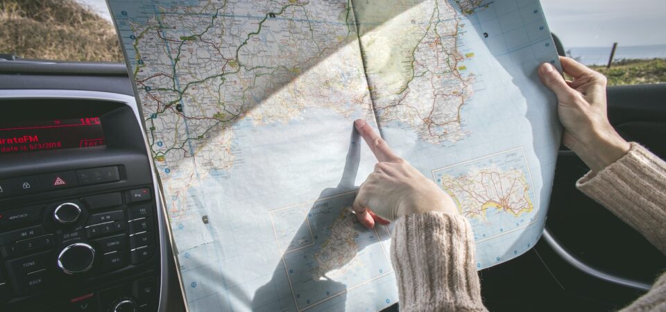 Person Wearing Beige Sweater Holding Map Inside Vehicle, rent a car